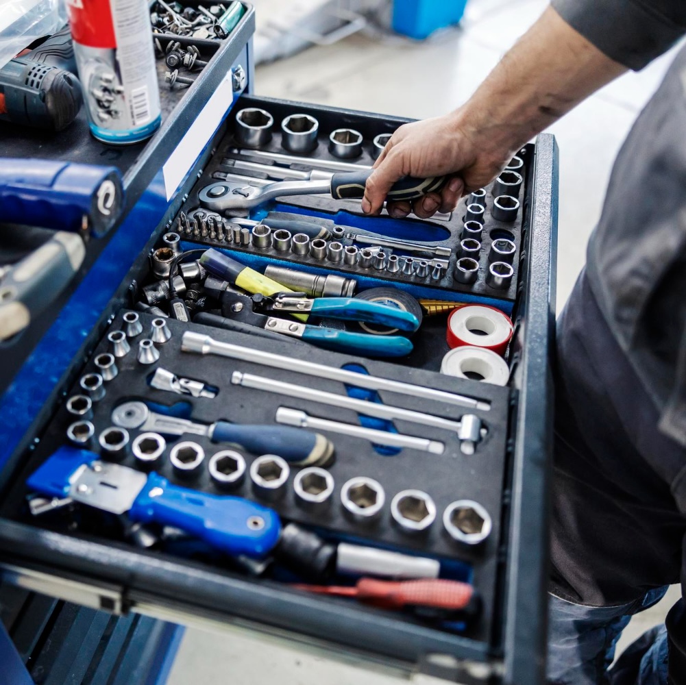 Technician selecting a socket from the tool chest during a car service